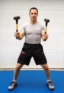Coach Kevin Kearns practices with sledgehammers
