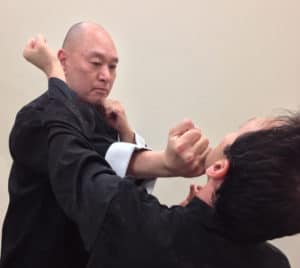 two men practicing martial arts wearing black clothes 